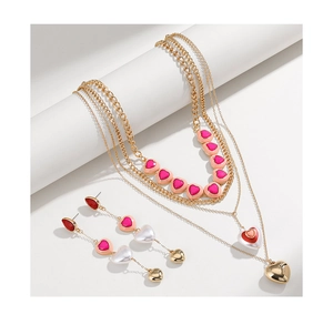 Detail view of multi-layer gold heart necklace and matching long drop earrings set