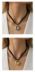 Dettaglio di ciondoli a cuore in metallo su choker in velluto nero nei colori oro e argento
