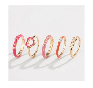Detail of 5-piece gold-tone ring set featuring colorful enamel and AMOR BABY XOXO letters