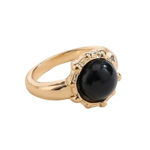 Retro gold plated ring featuring a polished round black gemstone inlay on white background