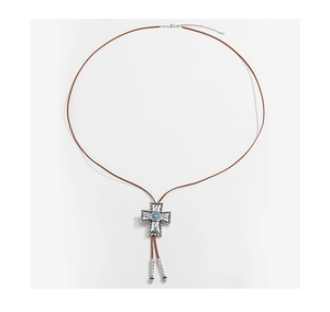 Detail van een vintage zilveren kruis bolo tie met turquoise steen en bruin lederen koord
