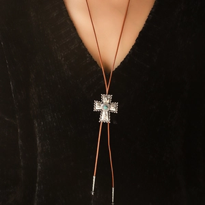 Vintage kruisketting met turquoise steen en bruin leren koord op een zwarte trui