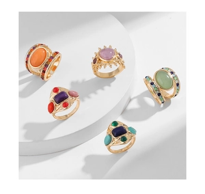 Detailed close-up of bohemian gold-plated rings with various colorful gemstones set