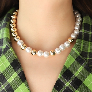 Choker ketting met grote gouden metalen kralen en witte parels voor een gelaagde dameslook