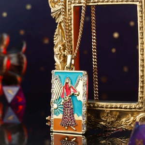 Macro shot of vintage gold tarot necklace with enamel angel pendant and red crystals