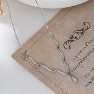 Elegante verzilverde gegolfde ketting met zirkonia druppelhanger op vintage kaart