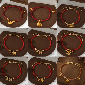 Close-up of nine red woven bracelets with diverse gold-plated zodiac horse and coin charms