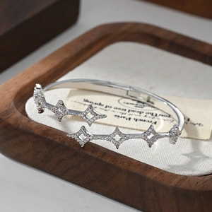 Elegant silver-colored crossover bangle featuring micro-pave star patterns and zircons