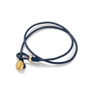 Macro view of blue leather wrap bracelet with gold charm engraved You Are My World