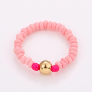 Detail of pink handmade beaded ring set featuring colorful beads and a gold accent bead