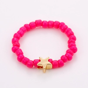 Detailed close-up of a pink beaded ring featuring a metallic gold star pendant charm