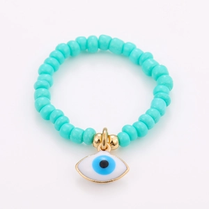 Detail of bohemian lake blue beaded bracelet with gold-rimmed evil eye charm