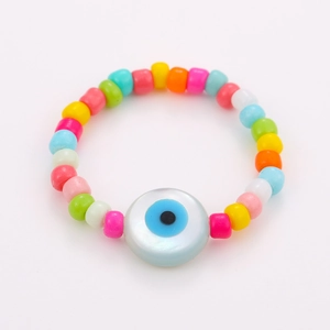 Macro view of colorful beaded ring set featuring an evil eye bead on white background