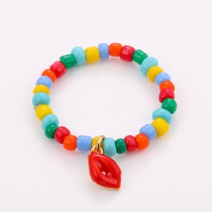 Detail of colorful beaded stacking rings featuring a vibrant red enamel lip pendant charm