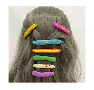 Détail des barrettes à cheveux ondulées en résine avec strass colorés aux tons acidulés