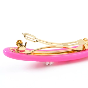 Barrette à cheveux rose bonbon en résine avec pince à ressort dorée sur fond blanc impeccable