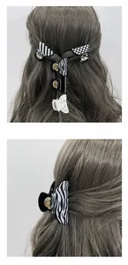 Detail shot of zebra print and pearl acrylic hair claws with product display on hair