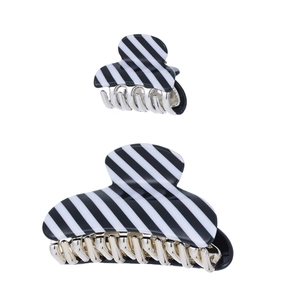 Detail view of black and white striped acrylic hair claw clips in two different sizes
