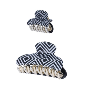 Close-up of black and white geometric pattern hair claw clips with gold metal teeth