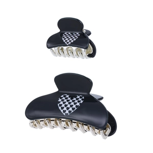 Detailed view of black and white heart pattern on acrylic claw clips in two sizes