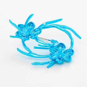 Futuristic electric blue metallic floral brooch with a glossy finish on white background
