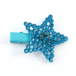 Close-up of bright blue star-shaped hair clip with sparkling rhinestones and metal duckbill