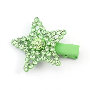 Detail of light green star-shaped hair clip with shimmering rhinestones and matte finish