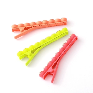 Three vibrant macaron-colored Y2K alligator hair clips in neon green, orange, and rose pink