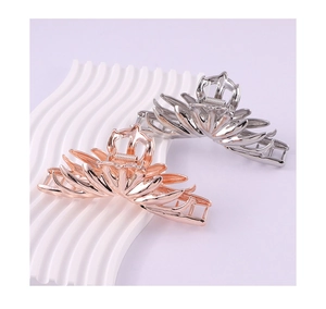 Close-up of lava texture metal hair claws in rose gold and silver finish with lotus design