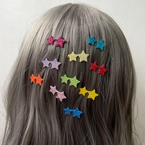 Glitzernde Doppelstern-Haarspangen in bunten Farben getragen auf grauem Haar