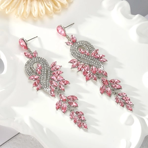 Détails macro des boucles d'oreilles à pompons en cristal rose avec motifs de feuilles