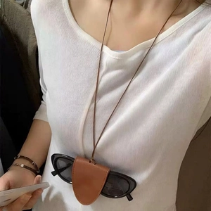 Detailaufnahme der braunen Leder-Brillenkette mit Clip an einem schwarzen Sonnenbrillen