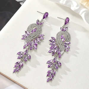 Vue macro des boucles d'oreilles punk en forme humaine 3D avec gemmes violettes et argent