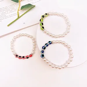 Detailed macro view of Baroque pearl bracelets with colorful evil eye charms and rhinestones