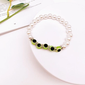 Detailed close-up of Baroque pearl evil eye beaded bracelet on a white display stand
