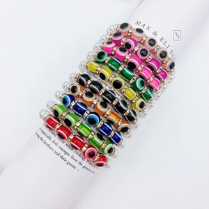 Close-up of colorful Evil Eye beaded bracelets with baroque pearls and gold spacers