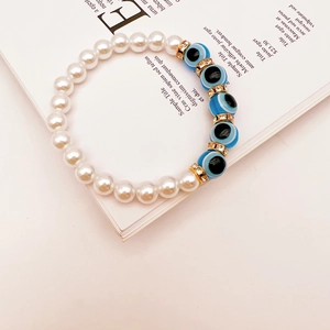 Detailed shot of Baroque pearls and blue Evil Eye beads on an open magazine