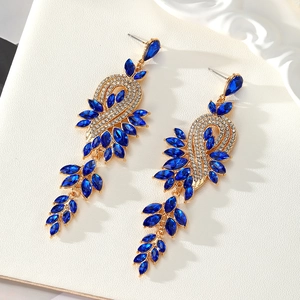 Macro detail of long tassel earrings with royal blue crystals and fine diamonds in gold setting
