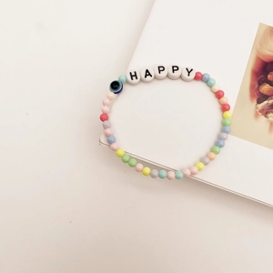 Détail d'un bracelet en perles colorées avec œil bleu et perles blanches HAPPY