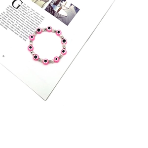 Bracciale malocchio con perle rosa e bianche su uno sfondo di rivista elegante