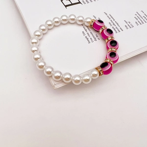 Detail of baroque pearls and pink evil eye beads with golden crystal spacers on a bracelet