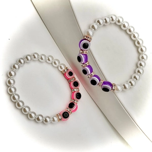 Macro detail of baroque pearl bracelets with evil eye beads and sparkling spacers