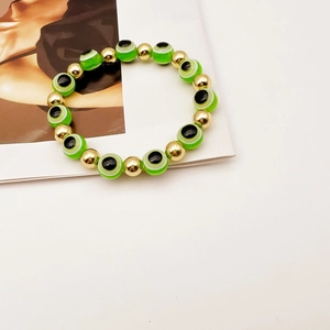 Dettaglio del bracciale turco con perline occhio del male verdi e sfere dorate lucide