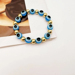Dettaglio del bracciale elastico Evil Eye con perline blu e accenti dorati