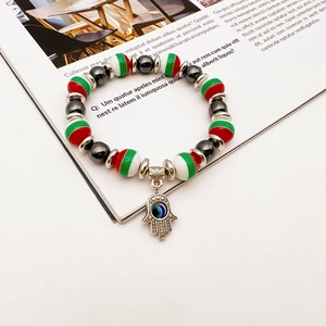 Detailed macro view of colorful Hamsa hand and Evil Eye charm on a beaded stretch bracelet