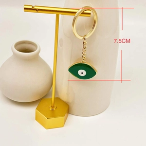 Detail of 7.5cm gold-tone keychain featuring a green Turkish evil eye pendant on a display