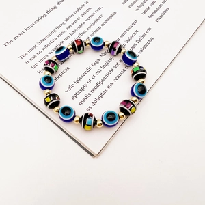 Detail of bohemian evil eye stretch bracelet with colorful beads and gold metal spacers