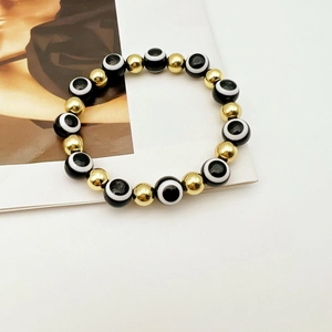 Dettaglio del bracciale turco Evil Eye con perline nere e finiture metalliche dorate