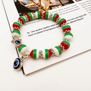 Handmade Christmas beaded bracelet with Hamsa Hand and Evil Eye charms on a magazine