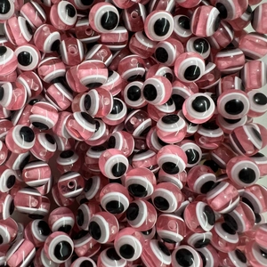 Macro detail of pink resin evil eye beads with polished finish for DIY jewelry making